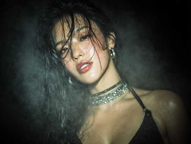 Confident woman with wet hair and a sparkly choker in a smoky setting.