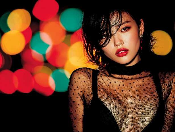 Stylish woman with red lipstick and a sheer top, Kuala Lumpur escort vibe.