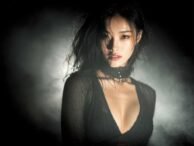 Sultry Asian woman with smoky eyes and a black choker. KL escort services.