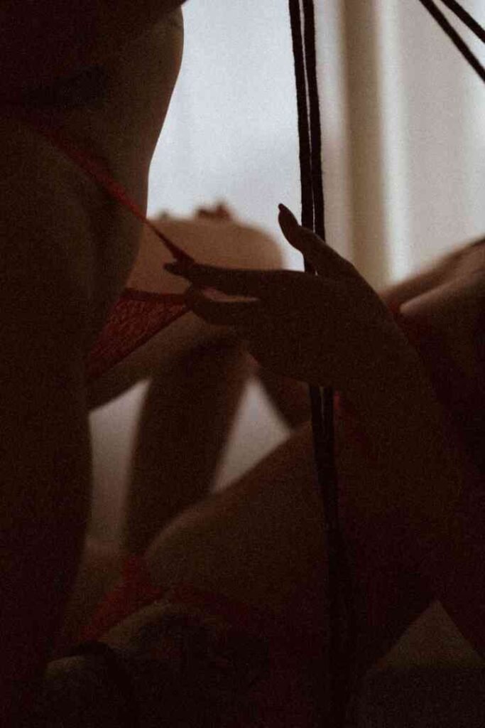 Close-up of Viola and Cici in intimate moment, sensual red lingerie