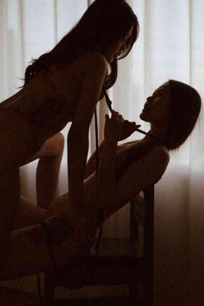 Two women in silhouette, one pulling the other's hair, suggestive of B2B escort services.
