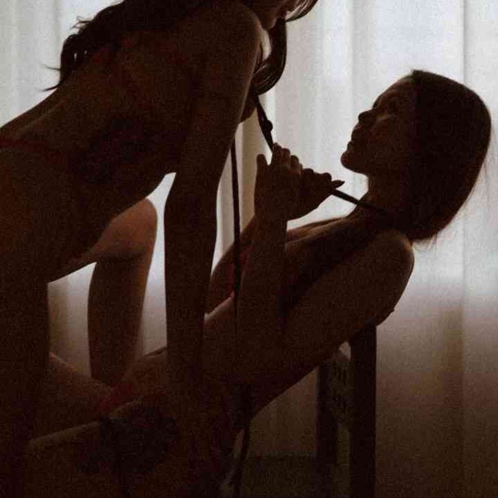 Two women in silhouette, one pulling the other's hair, suggestive of B2B escort services.
