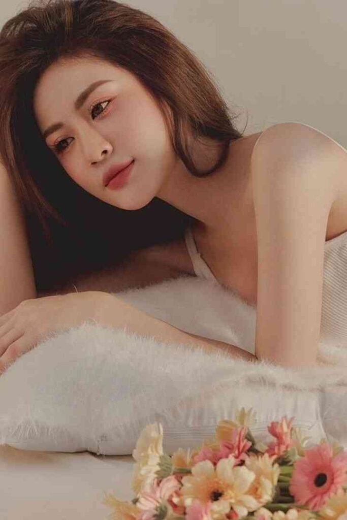 Tina, 23yo Malay escort in KL, lying on bed with flowers