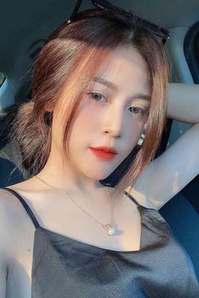 Tina, a 23yo Malay escort in KL with C cup, wears a necklace in a car