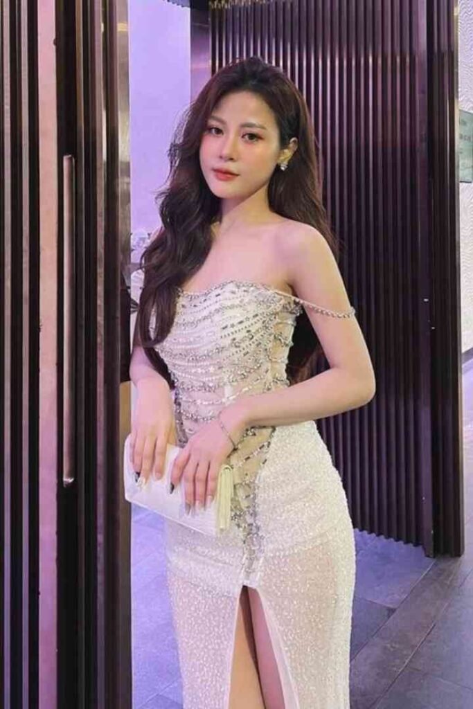 Tina, 23yo Malay escort in gold sequined gown, holding white clutch