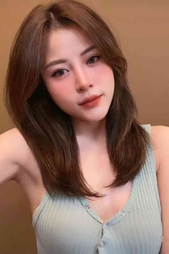 Tina, 23, with brown hair and light makeup, wearing a light green top.