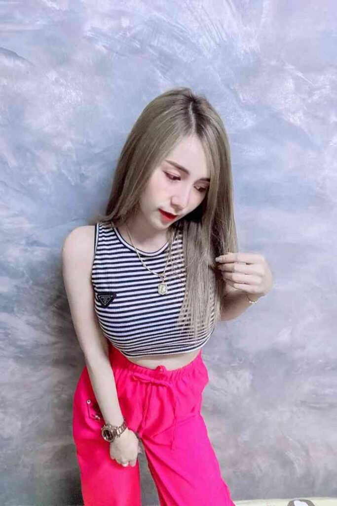 Amy, a 23yo Thai woman, in a striped top and pink pants