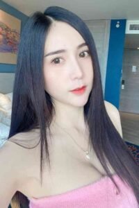 Young woman with long dark hair and a pink top