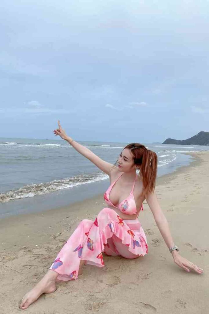 Woman in pink bikini and pants on beach