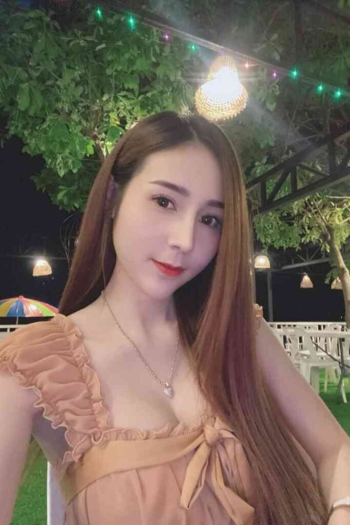 Amy, a 23-year-old Thai escort in KL, with C cup, in a peach dress