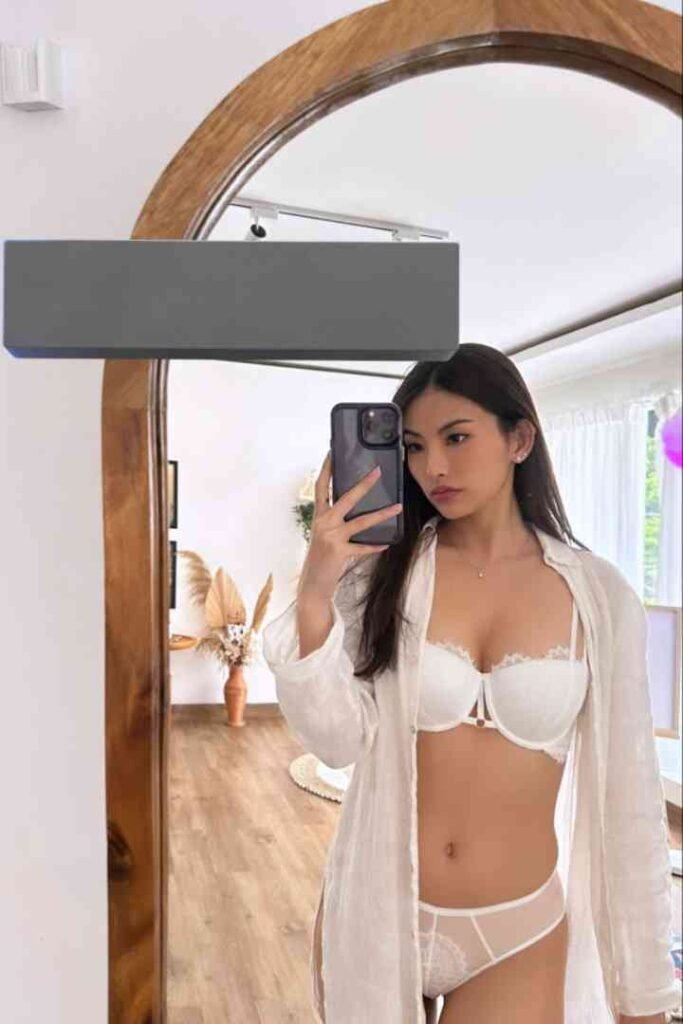 Dewi, 22yo, in white lingerie, posing for a mirror selfie in KL.