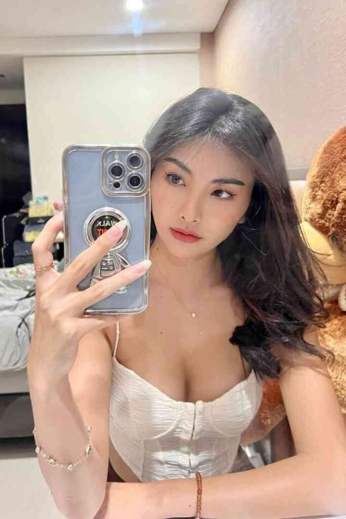 Dewi, a 22yo Malay woman, poses for a selfie in KL, showcasing her B cup and B2B massage services.