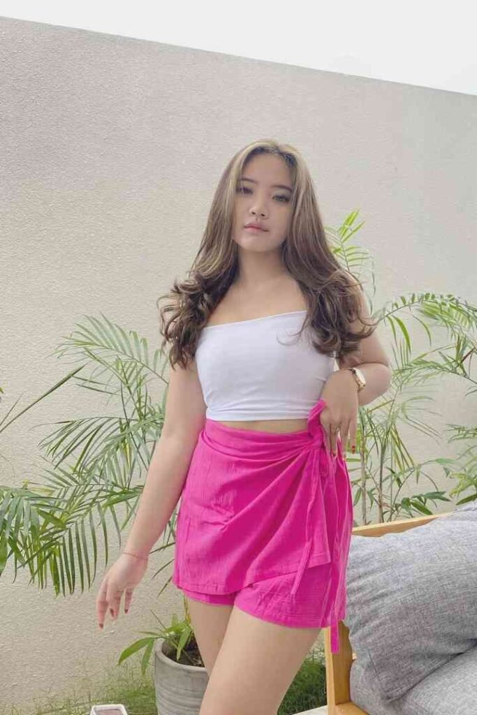 Fitri, 23yo local Malay escort in pink shorts and white top, posing outdoors