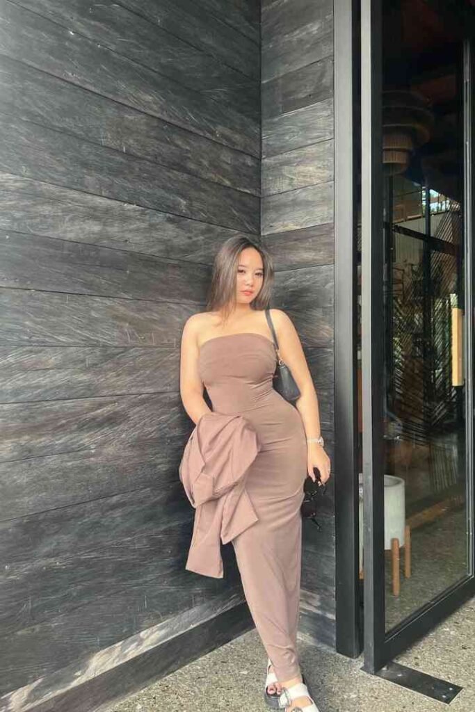 Fitri, a 23-year-old local Malay escort in KL, stands outside a wooden wall