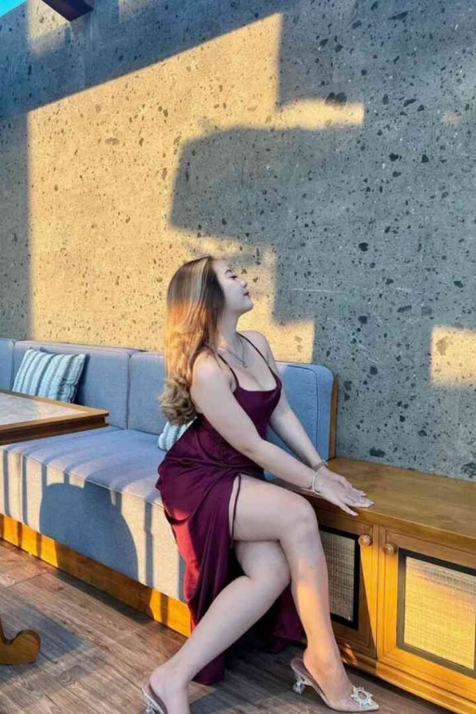Fitri, a local Malay escort in KL, poses in a maroon dress and high heels