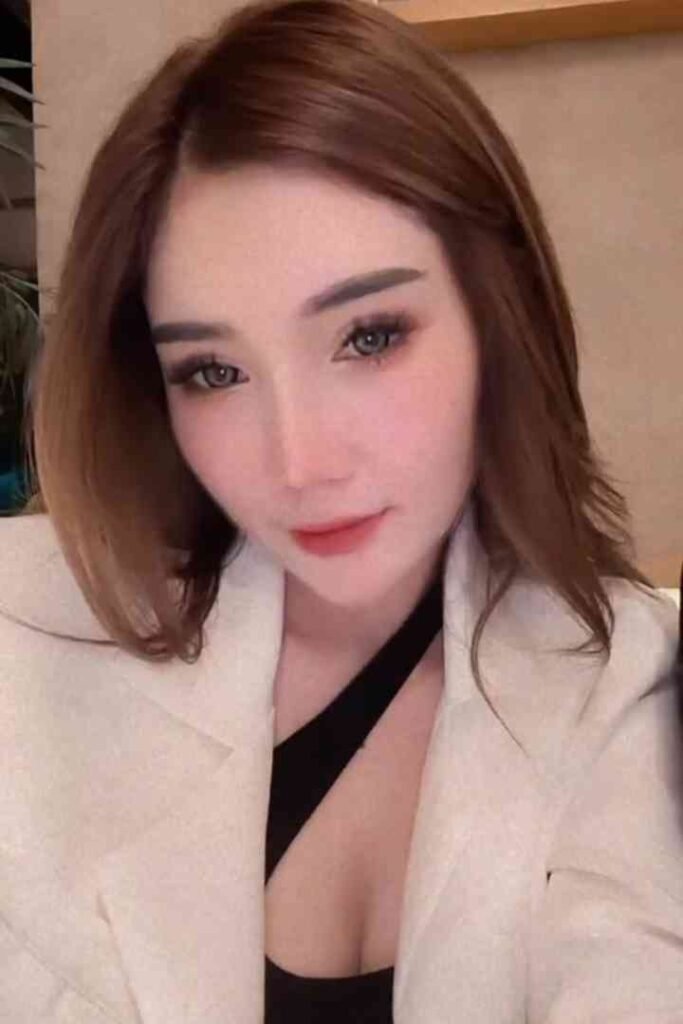 Kenzo, 23yo Malay escort in KL, wearing white blazer, smiling at camera