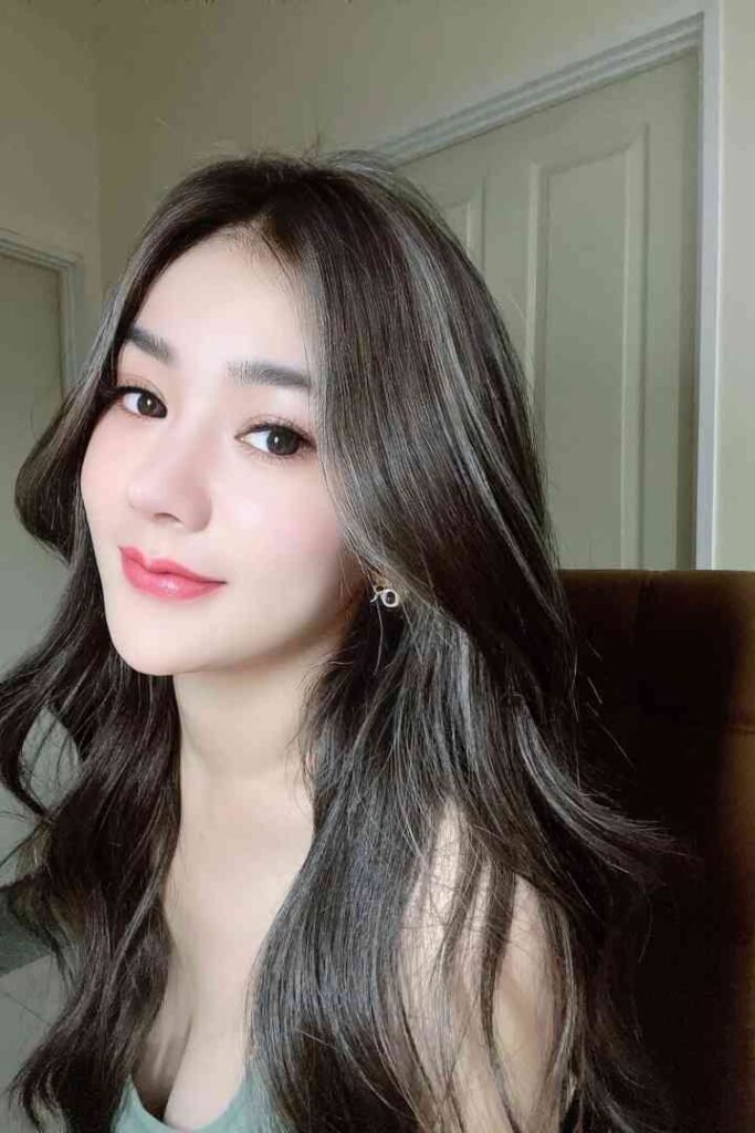 Young Thai woman with long dark hair and makeup, Kaylee