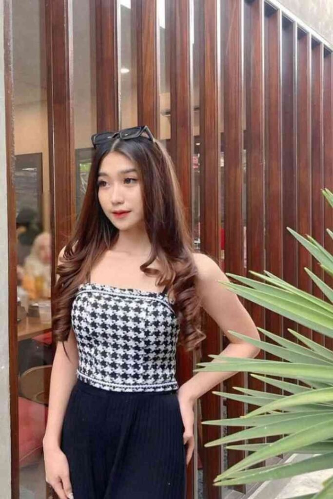 Young Malay woman in Kuchai Lama, wearing a black and white checkered top and black pants