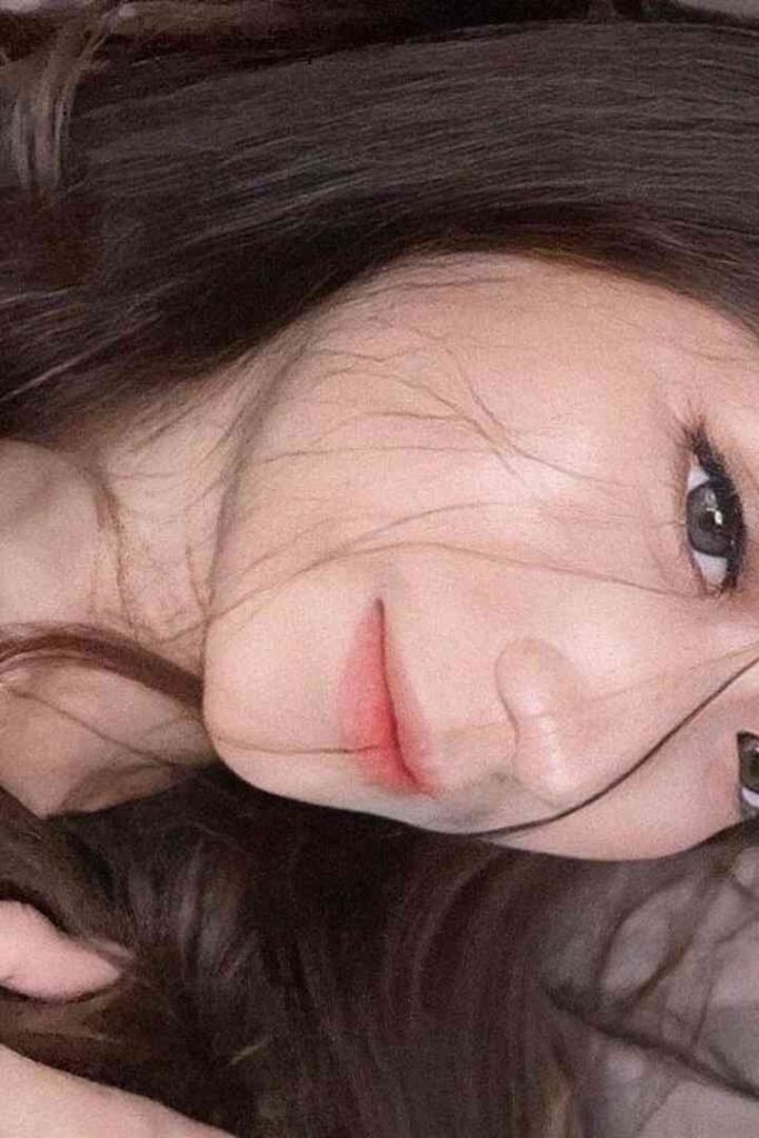 Close-up of a young woman's face with dark hair and subtle makeup