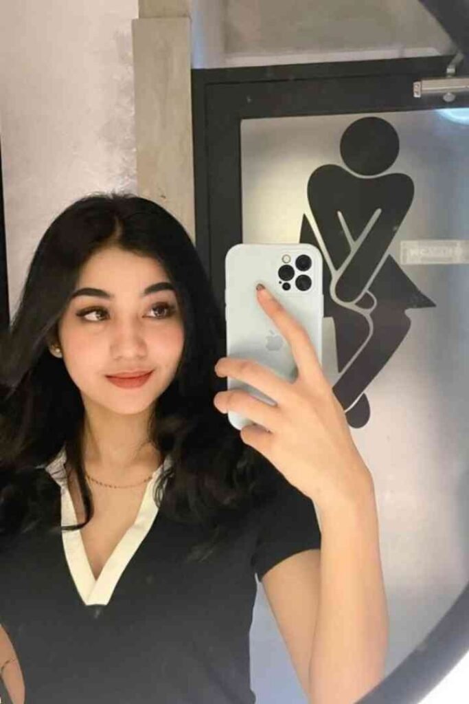 Young Malay woman taking a selfie in a restroom