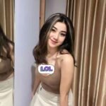Woman in beige top and skirt smiling at mirror, LOL sticker