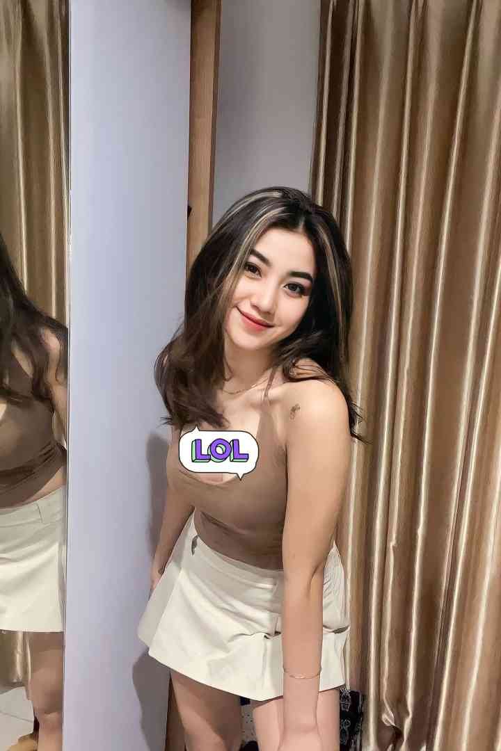 Woman in beige top and skirt smiling at mirror, LOL sticker