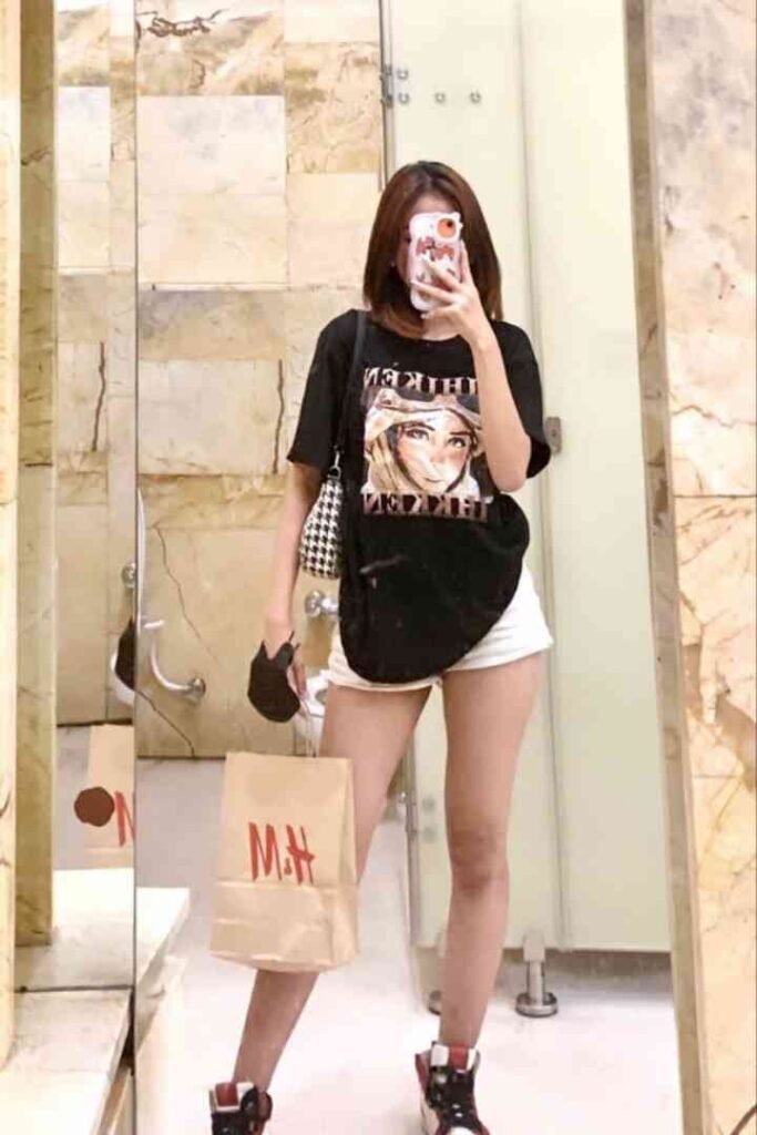 Local Malay escort in black shirt taking selfie with M&H bag