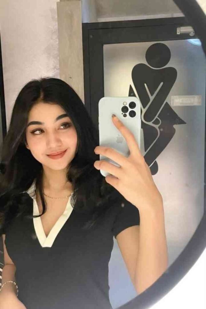 Young Malay woman taking a mirror selfie in a restroom