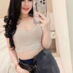 Smiling woman in bedroom taking selfie with iPhone 13 case