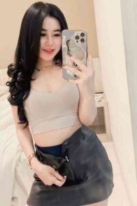 Smiling woman in bedroom taking selfie with iPhone 13 case