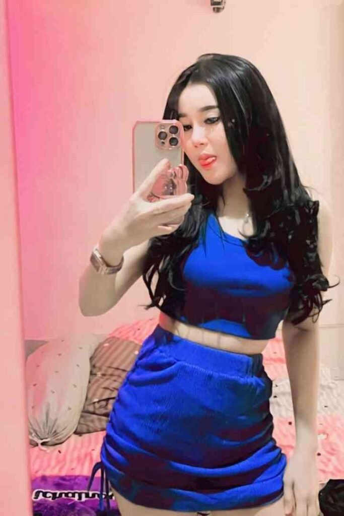Sweet Sarah in blue dress taking selfie in bedroom
