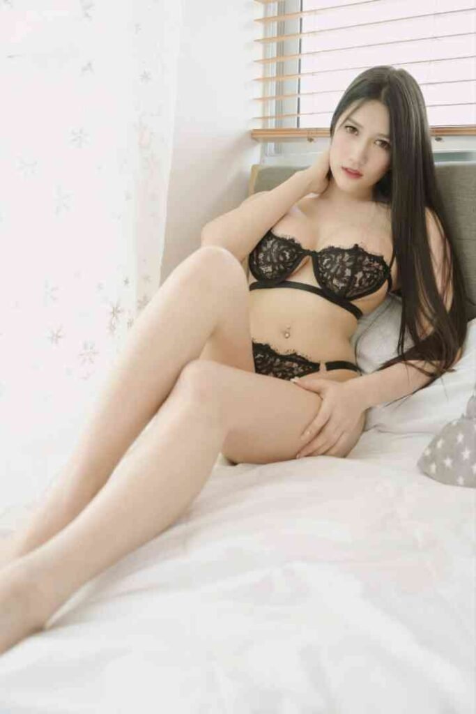 Young Thai woman in black lingerie on a bed