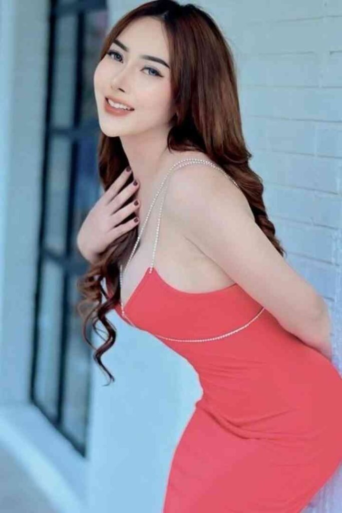Sindy, a young Malay woman, poses in a red dress for an escort service in KL