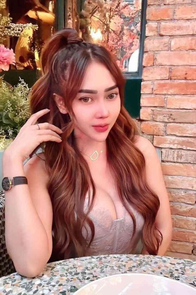 Malay call girl Sindy with long brown hair, wearing a pink dress and necklace