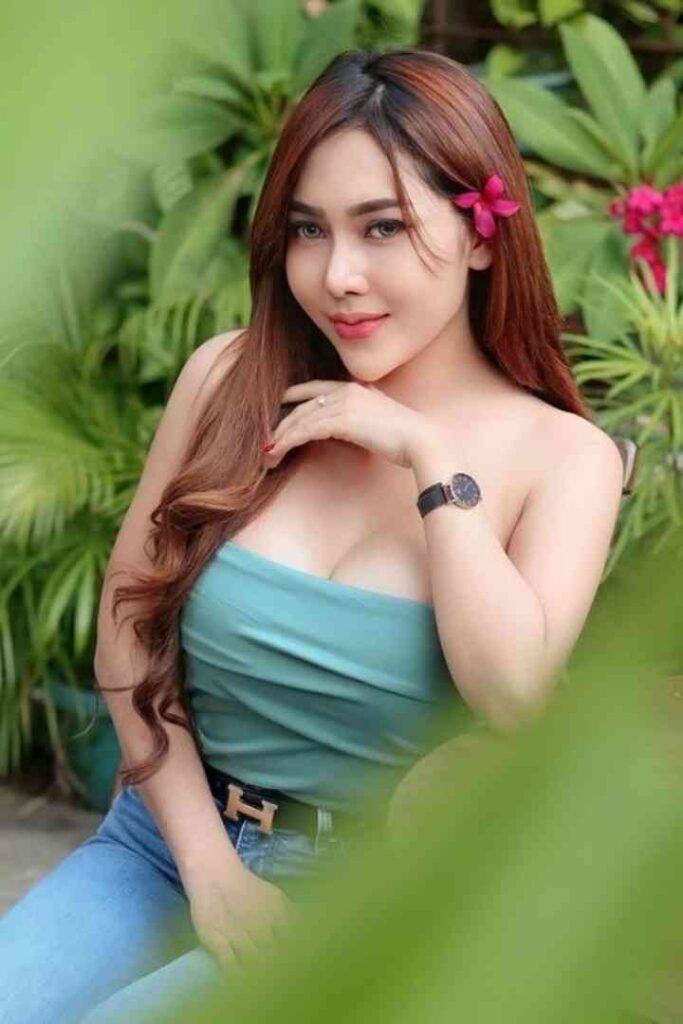 Sindy, a young Malay call girl, sitting in a garden wearing a teal top