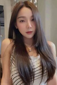 Woman with long hair wearing a black and white striped top and necklace
