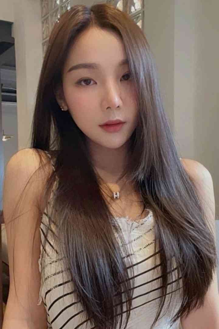 Woman with long hair wearing a black and white striped top and necklace