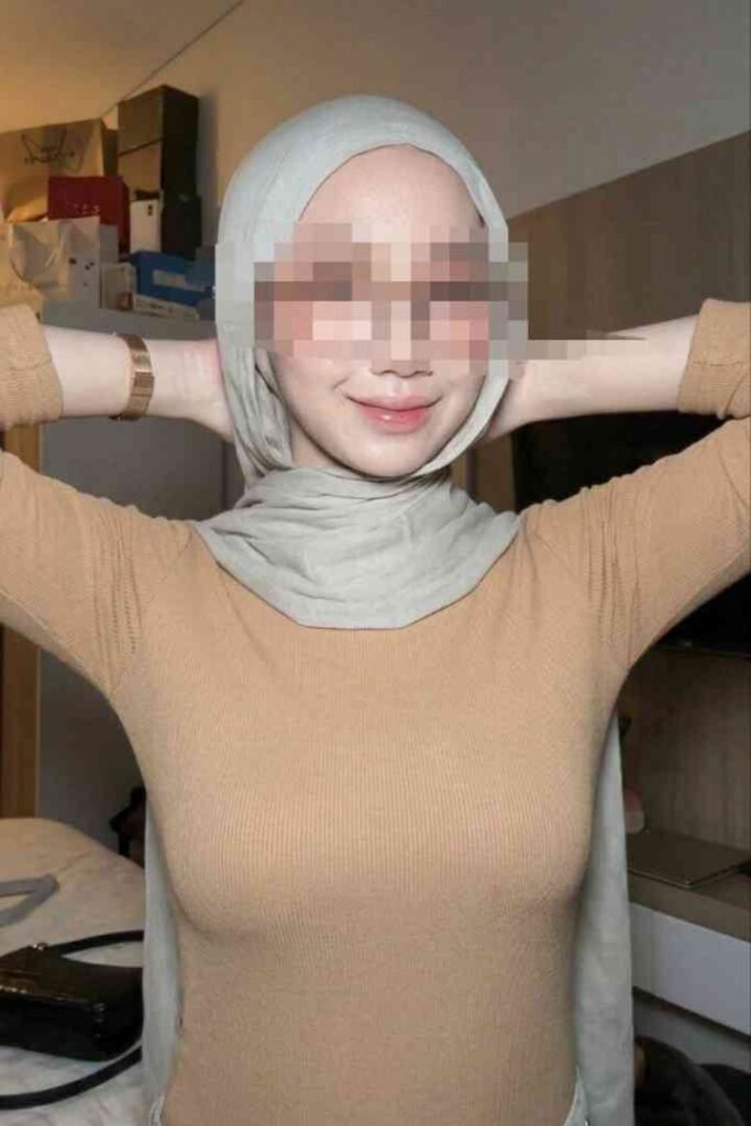 Woman wearing a hijab and a tan top, with blurred face